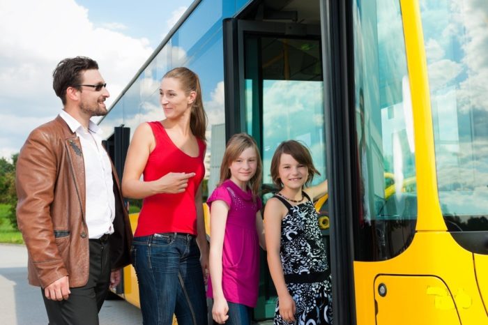 семья из 2 взрослых и 2 детей садятся в автобус для путешествия