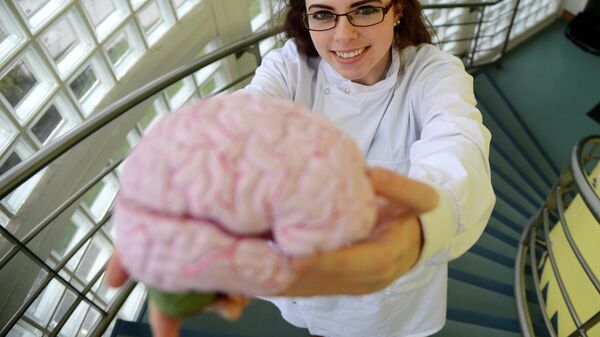 Ученый держит в руках мозг человека, страдавшего болезнью Альцгеймера