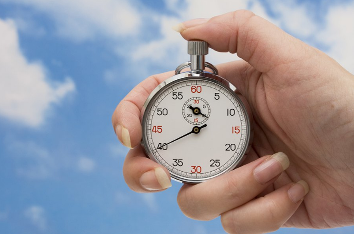 A hand holds a stopwatch ready to start the timer whenever it