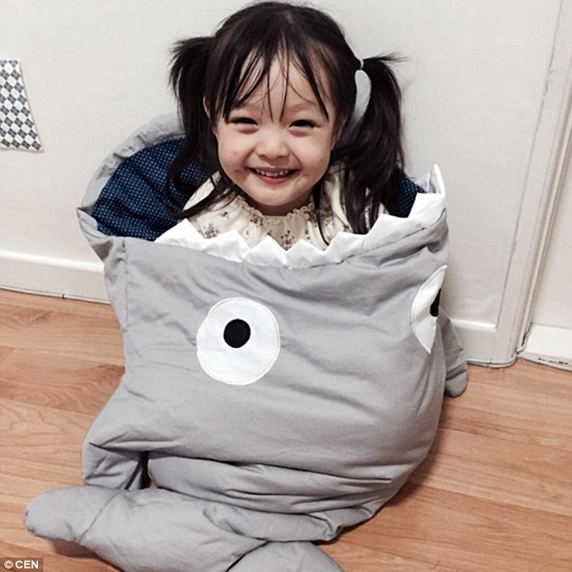 Jae-eun flashes a mischievous grin as she is bundled inside a shark-themed sleeping bag 