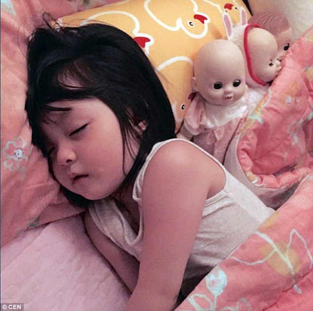 Adorable Jae-eun is pictured fast asleep in her pink bedding snuggled up next to her toy dolls