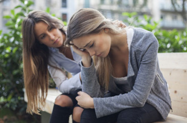 Две девушки сидят на улице. у одной депрессия. Вторая пытается ее успокоить