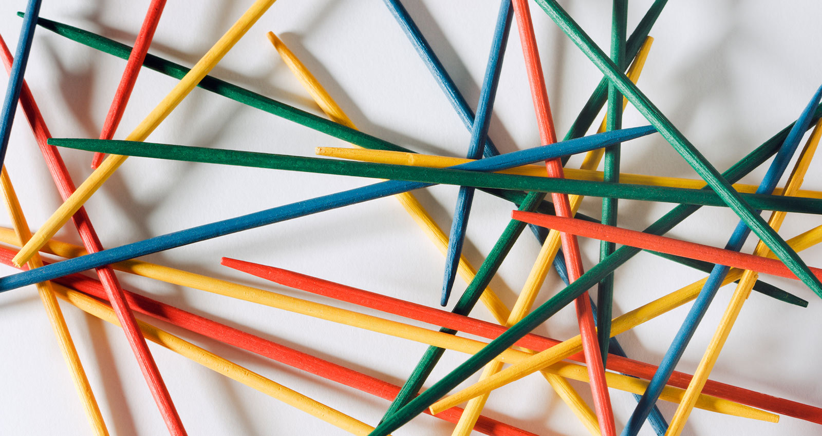 A close-up photo of brightly colors Pick Up Stix stacked and intersecting representing the holistic approach to social work.