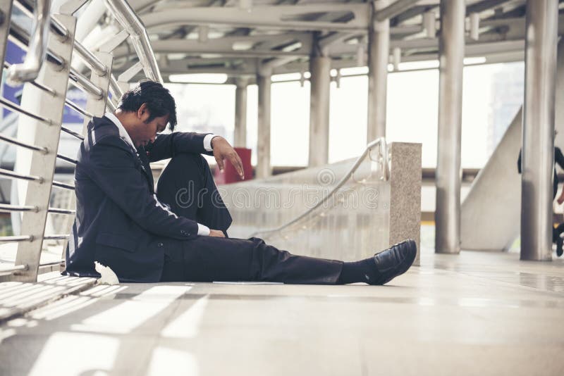 Failure businessman sitting on dirty ground. Middle age crisis.  stock photo