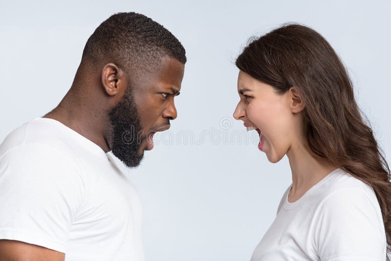 Interracial couple arguing, yelling at each other, having relationship crisis. Interracial couples problems. Young men and women yelling at each other, arguing royalty free stock photography