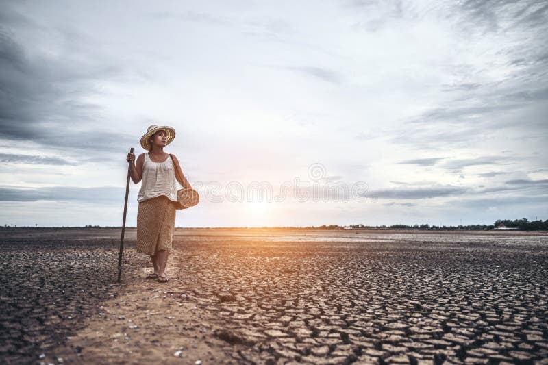 Women standing on dry soil and fishing gear, global warming and water crisis. Women  standing on dry soil and fishing gear, global warming and water crisis stock photo