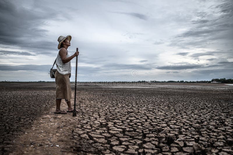 Women standing on dry soil and fishing gear, global warming and water crisis. Women  standing on dry soil and fishing gear, global warming and water crisis stock photography