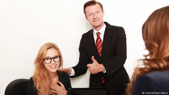 Девушка улыбается, стоящий рядом мужчина показывает большой палец в знак одобрения.