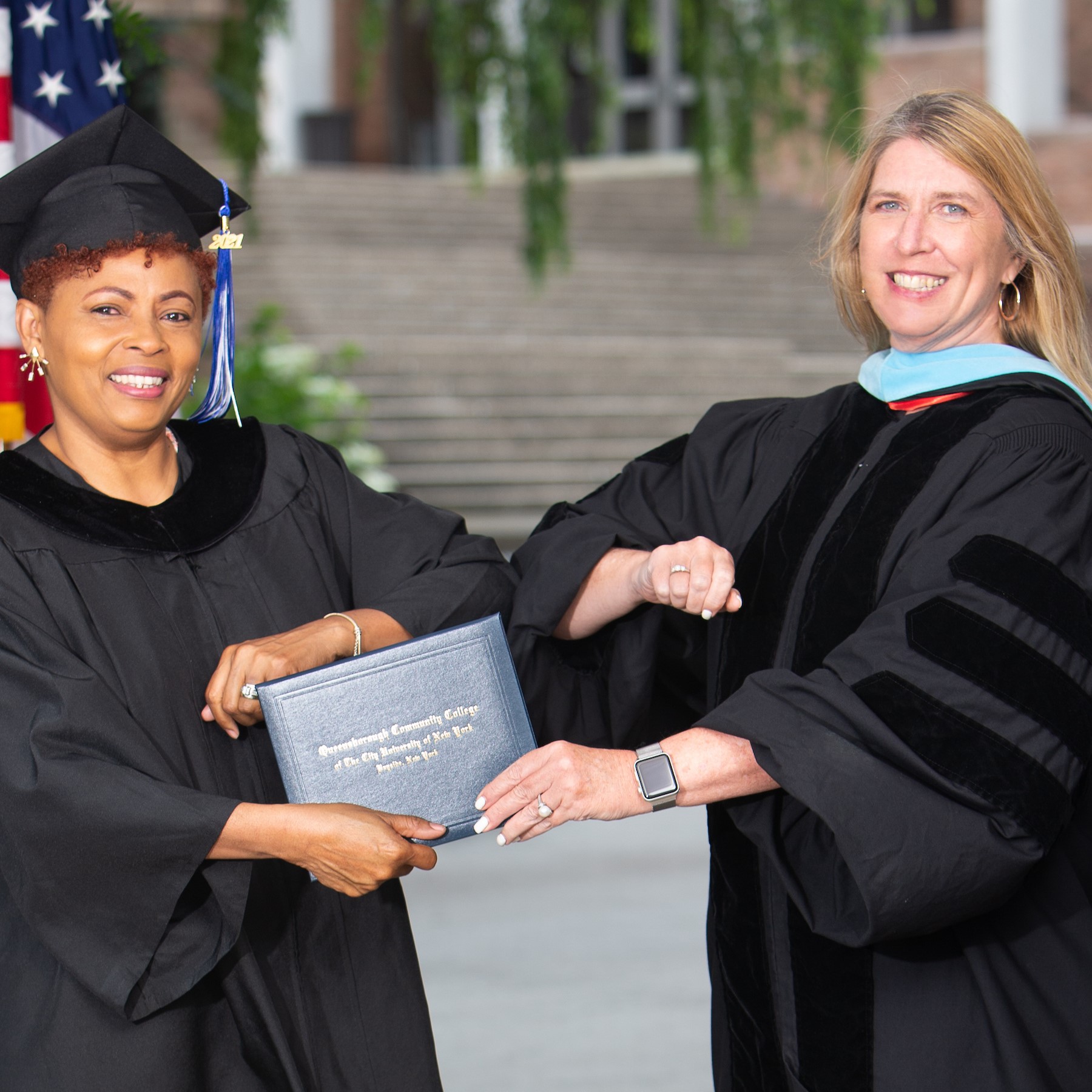 Nicole Hudson bumps elbows with Queensborough Community College President Dr. Christine Mangino