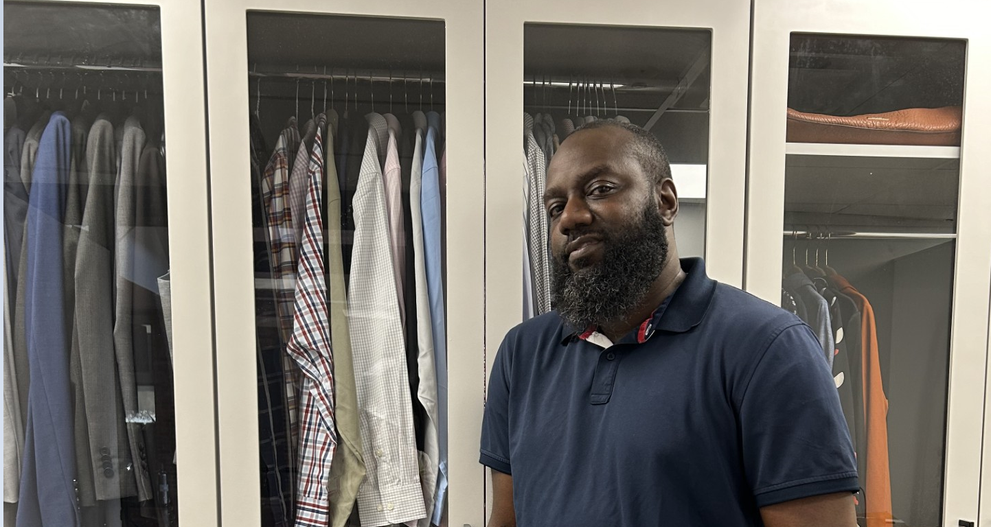 Jamal Biggs, Director of Male Resource Center, next to wardrobe