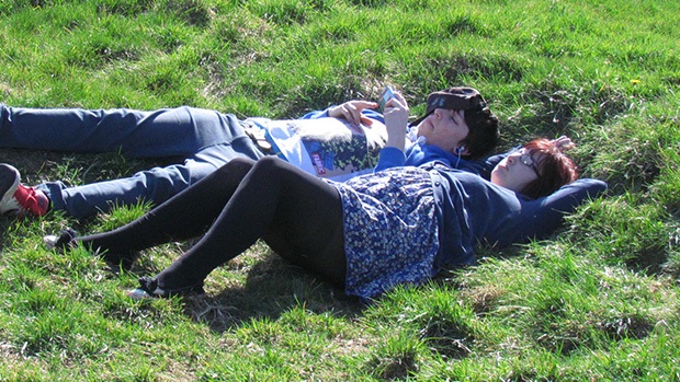 Two teenagers lying in a grassy field